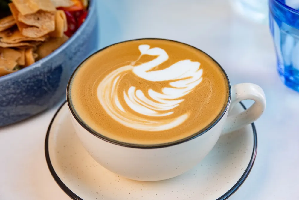 A specialty latte with swan latte art