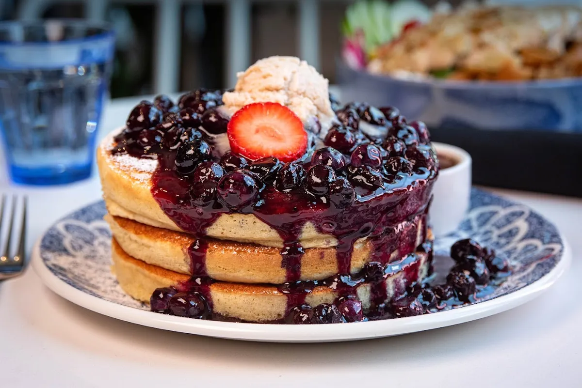 Fluffy pancakes with blueberry compote, strawberry and whipped butter